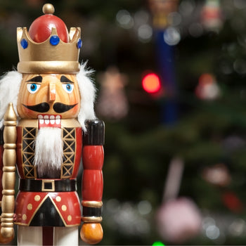 vintage nutcracker in front of a chirstmas tree