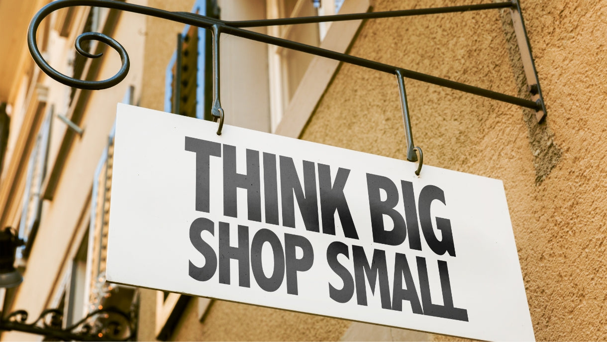 photo of a building sign that says 'think big shop small' in black block letters